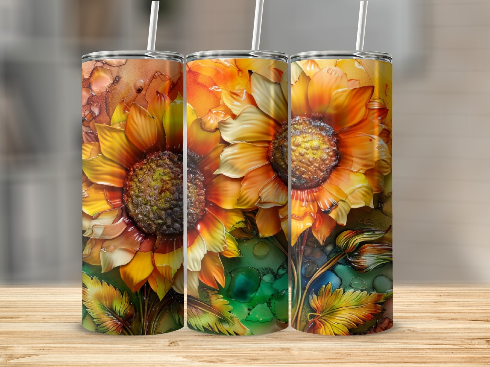 Three tumblers with a vibrant sunflower design, set on a wooden surface.