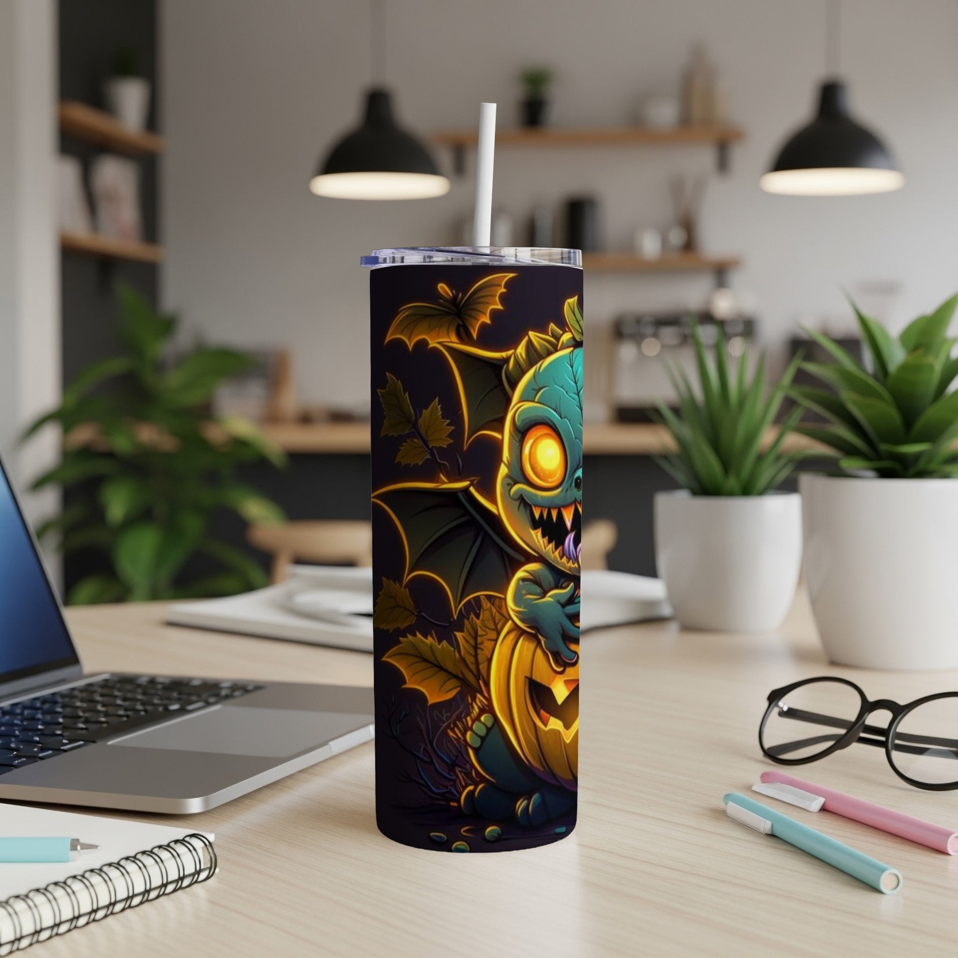 Halloween tumbler with a teal monster holding a jack-o-lantern and bat wings.