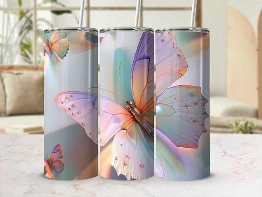 Three tumblers with iridescent butterfly designs against a soft background.