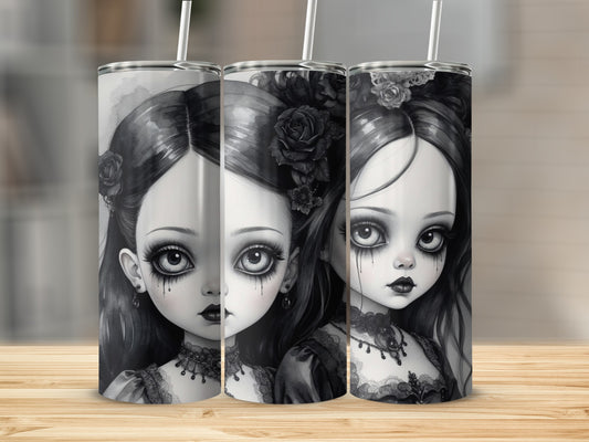 Three gothic dolls with dark makeup and elaborate hairstyles on tumblers.