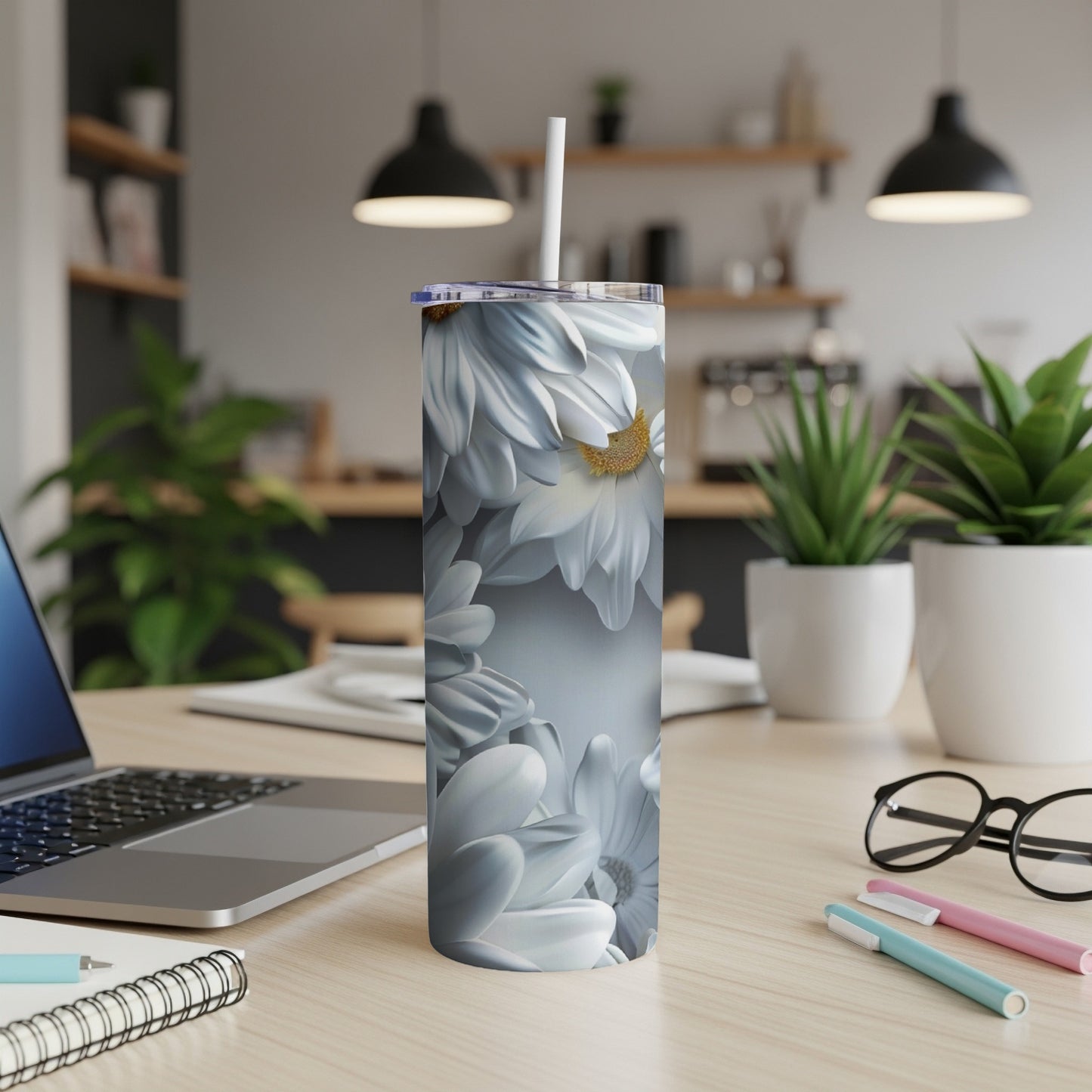 White daisy flowers wrap around a white tumbler with a straw.