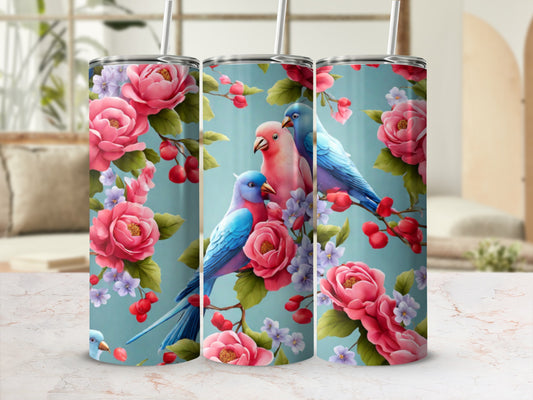 Two blue and one pink parakeet perched on a branch with pink roses.