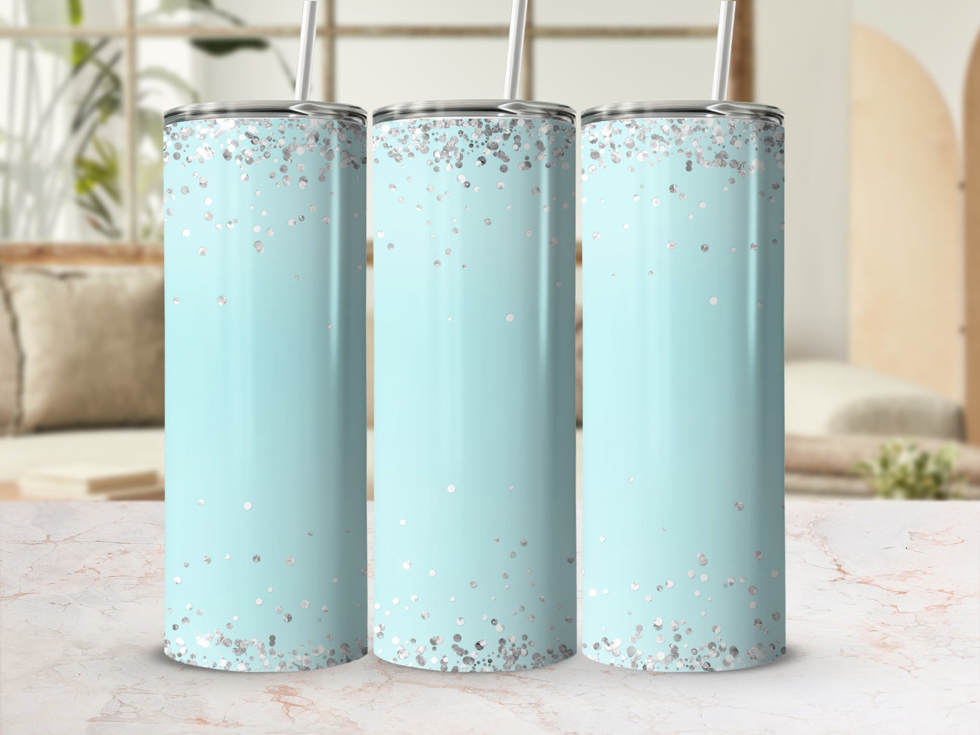 Three light blue tumblers with silver confetti pattern and silver lids with straws.