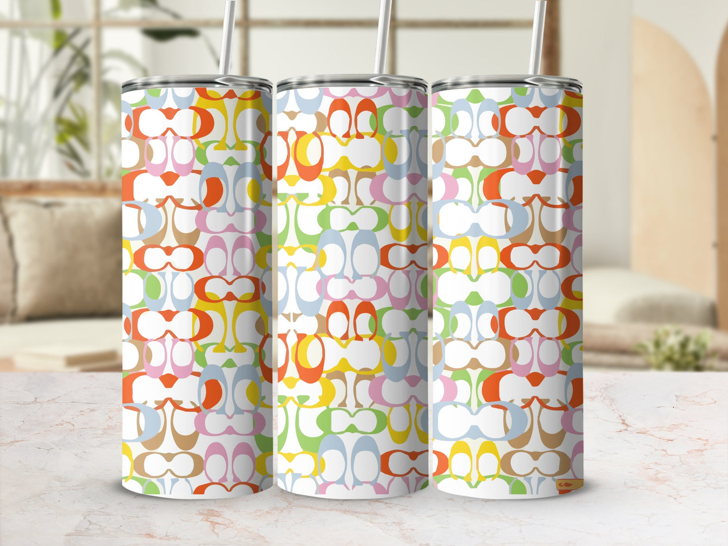 Three tumblers with a colorful interlocking 'C' pattern and straws.