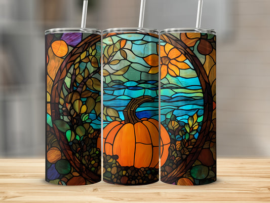 Tumbler with stained glass pumpkin design featuring autumn leaves and a lake.