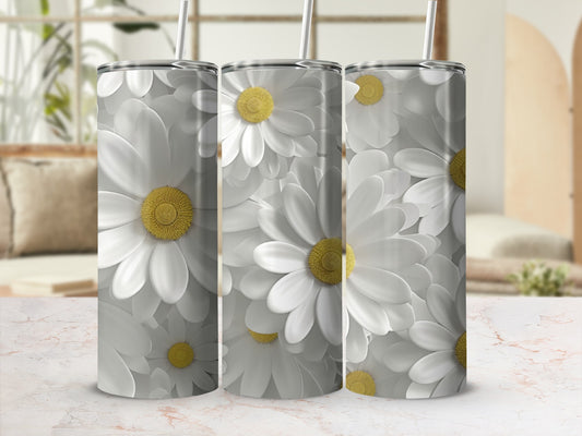 Three white daisy print tumblers with straws on a marble surface.