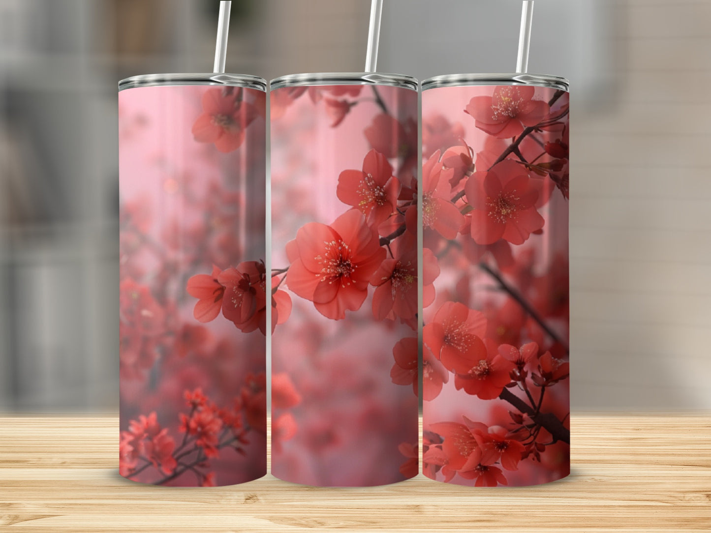 Three tumblers with pink floral cherry blossom design on wooden surface.