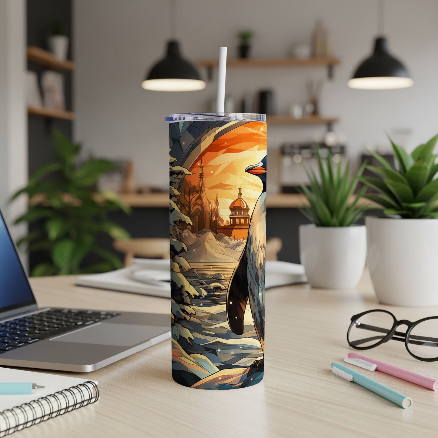 Penguin in a snowy landscape on a colorful tumbler with a straw.