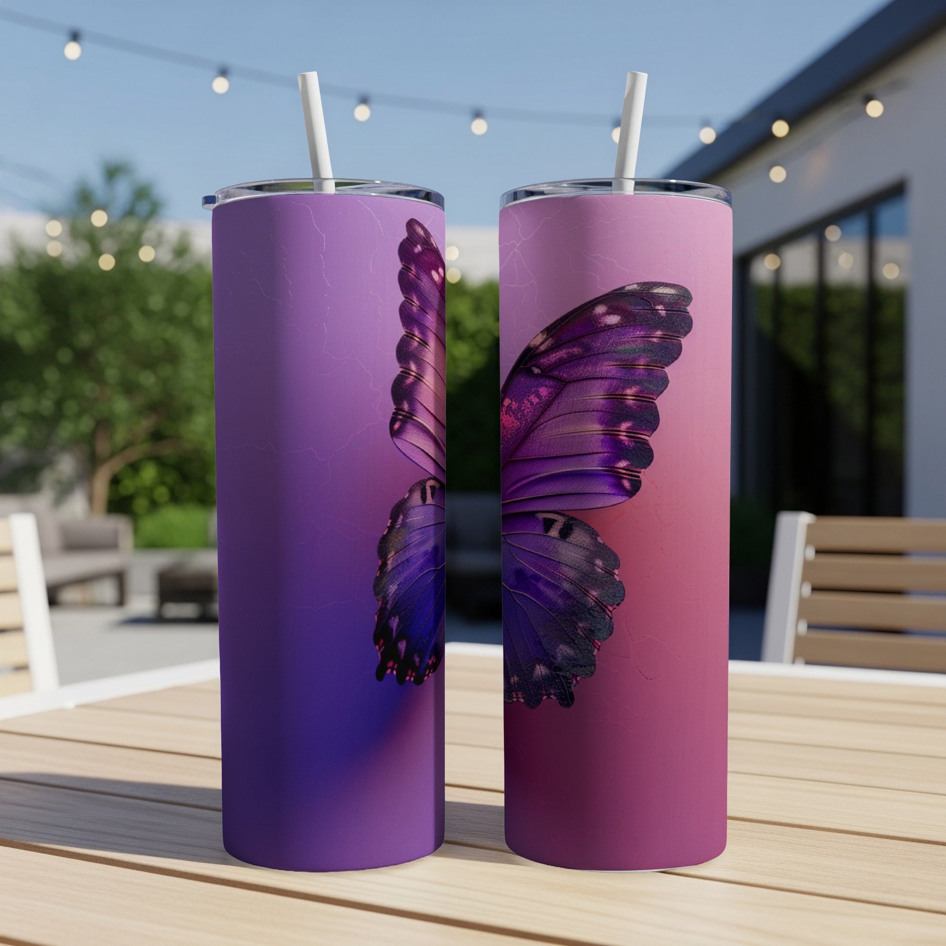 Two purple and pink tumblers with butterfly wing designs on a wooden table.