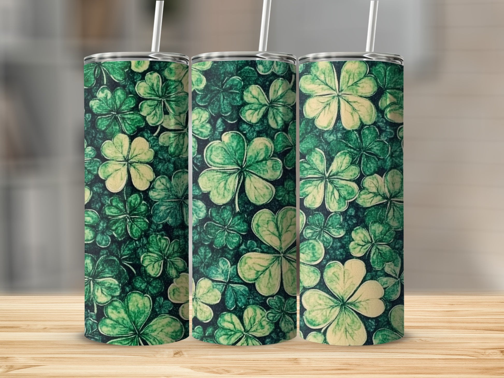 Three green tumblers with a repeating shamrock pattern.