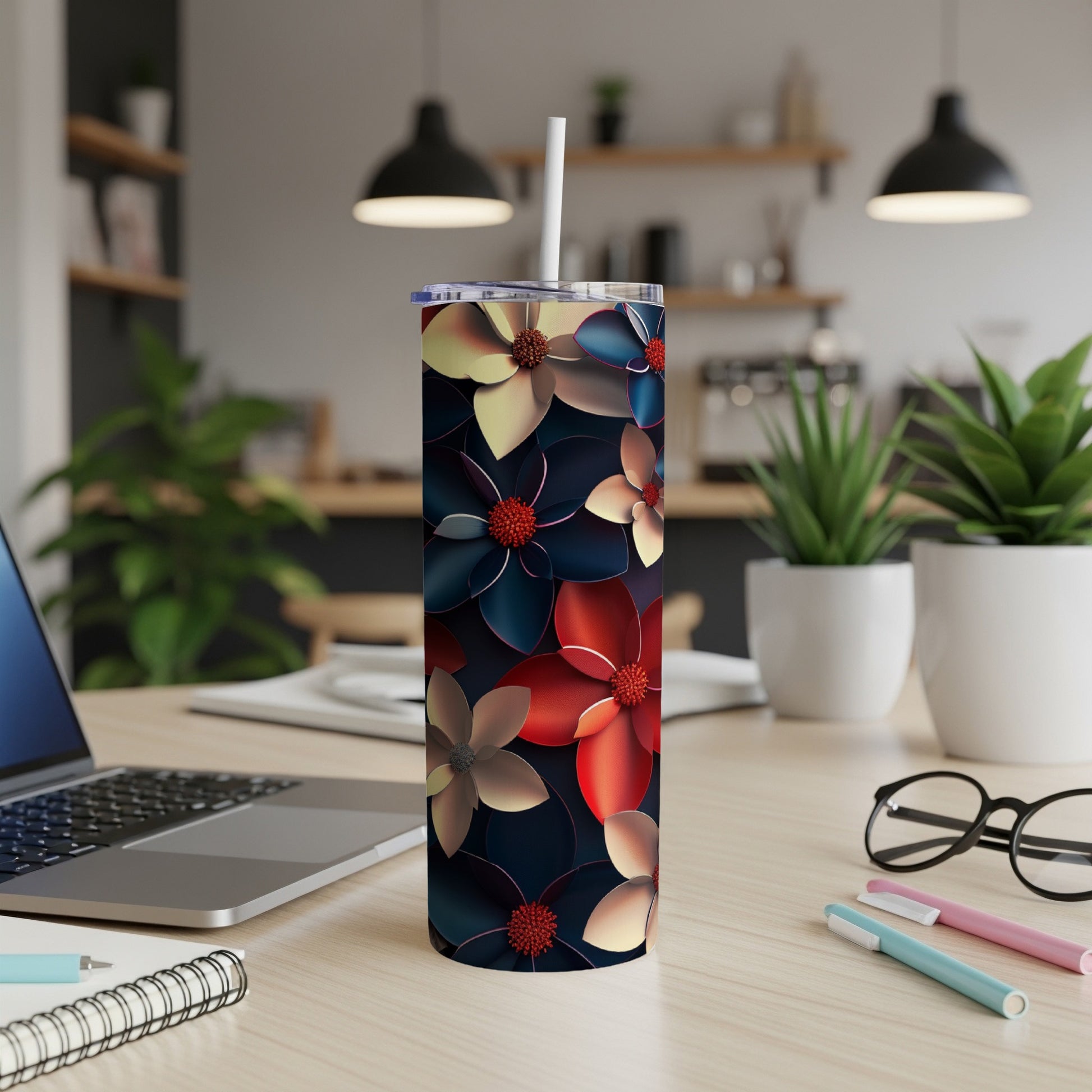 Floral pattern skinny tumbler with a straw on a desk.