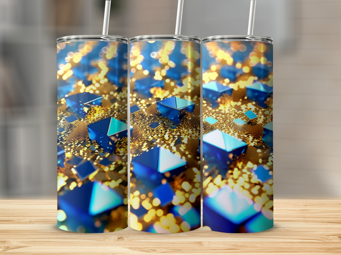 Three tumblers with abstract blue geometric shapes and gold bokeh on a wooden surface.