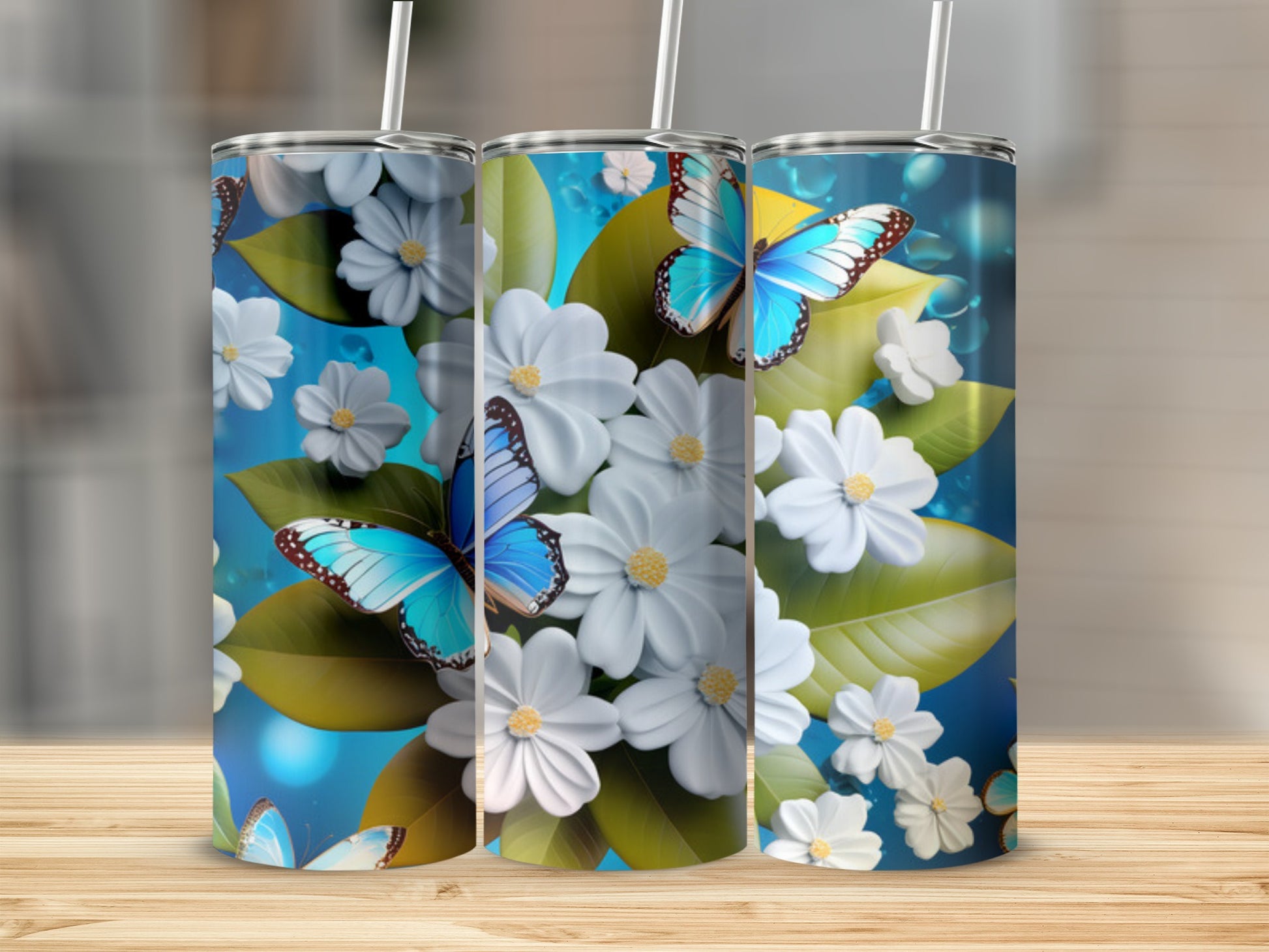 Blue butterfly and white flower floral pattern on three cylindrical tumblers.
