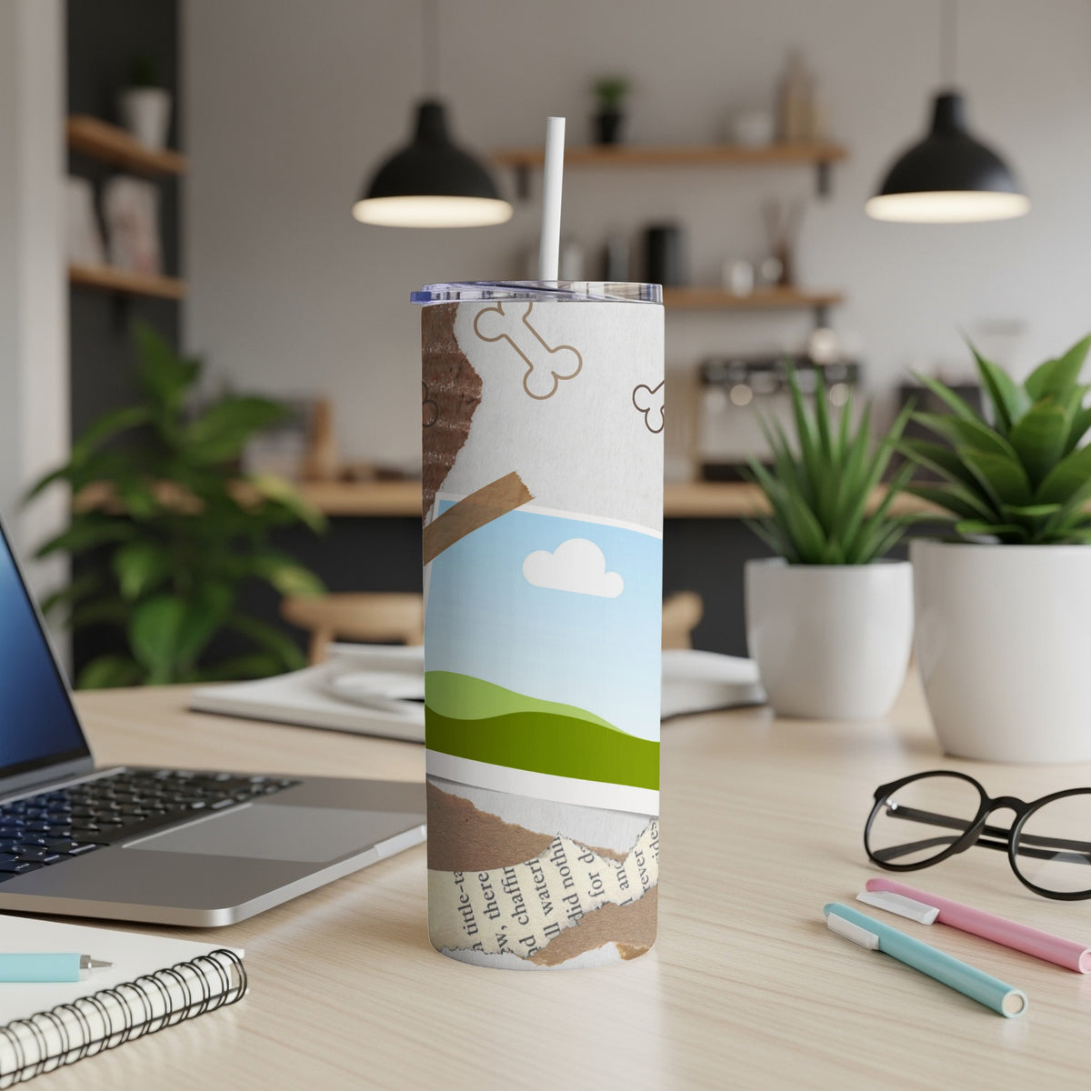 Tumbler with ripped paper design, dog bones, and landscape graphic.