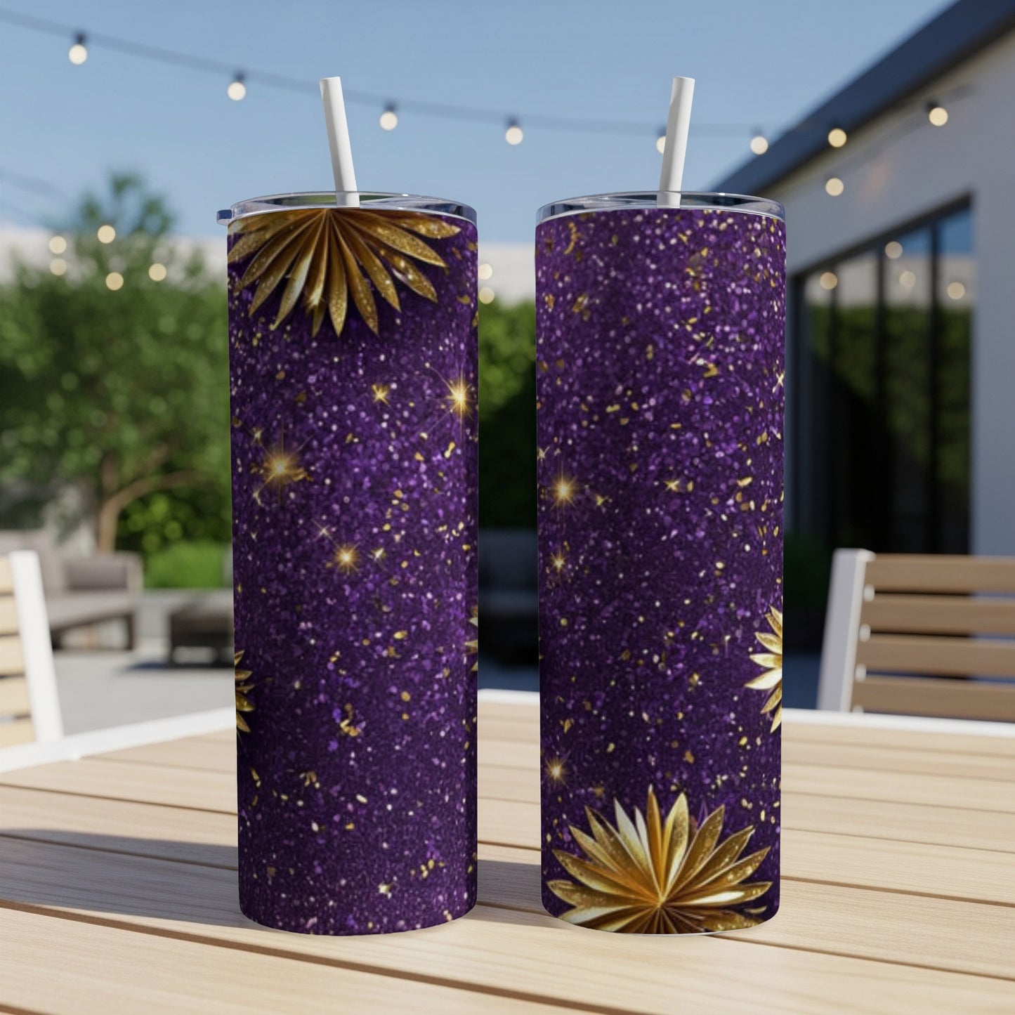 Two purple glitter tumblers with gold starbursts and straws on a table.