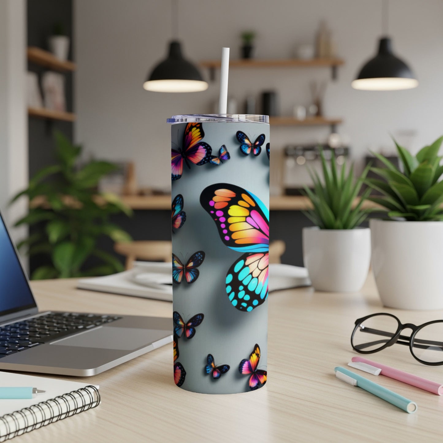 Butterfly pattern on a gray tumbler with a white straw.