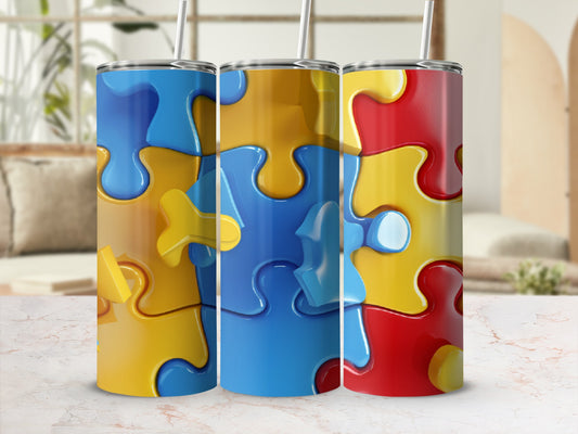 Three tumblers with colorful puzzle piece designs in yellow, blue, and red.