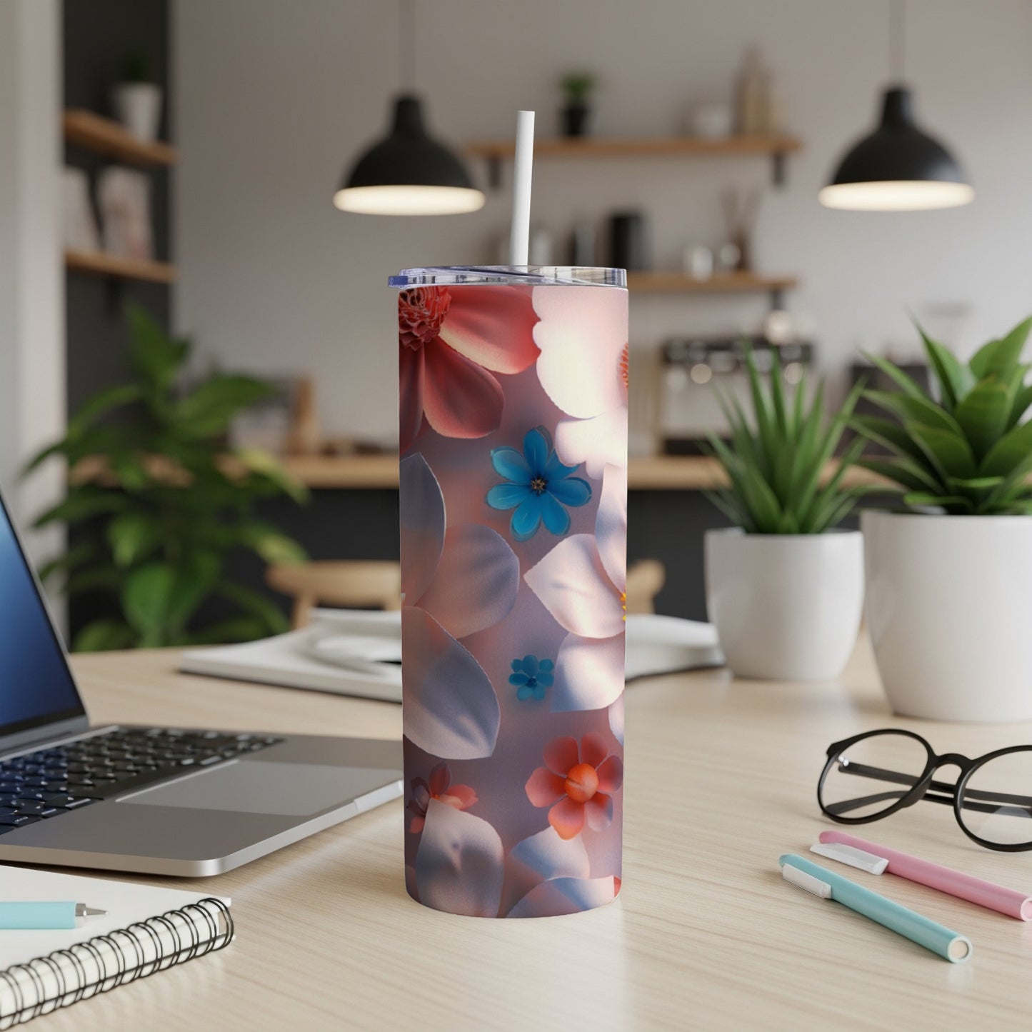 Tumbler with floral pattern and straw on a desk.
