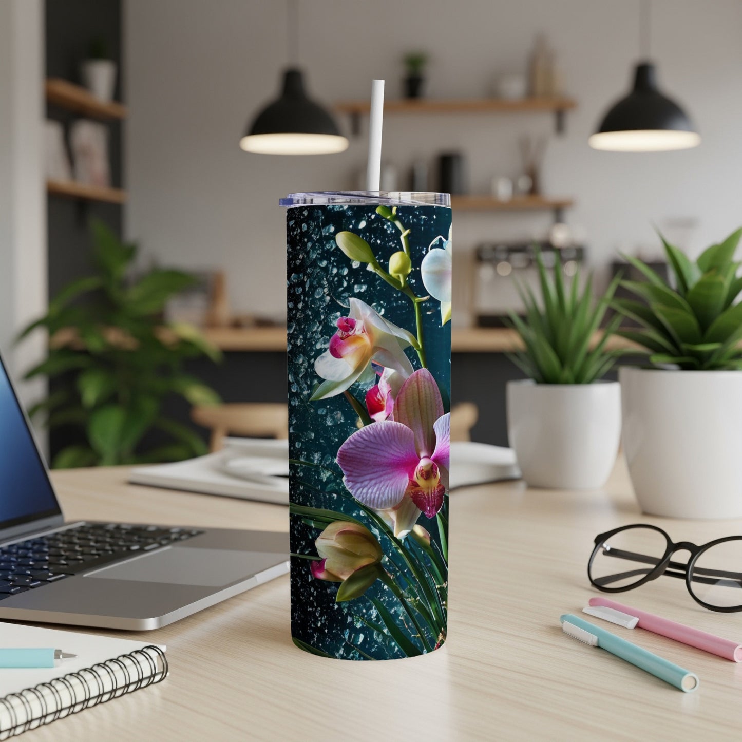 Orchid flowers with water droplets on a dark background wrap around a skinny tumbler.