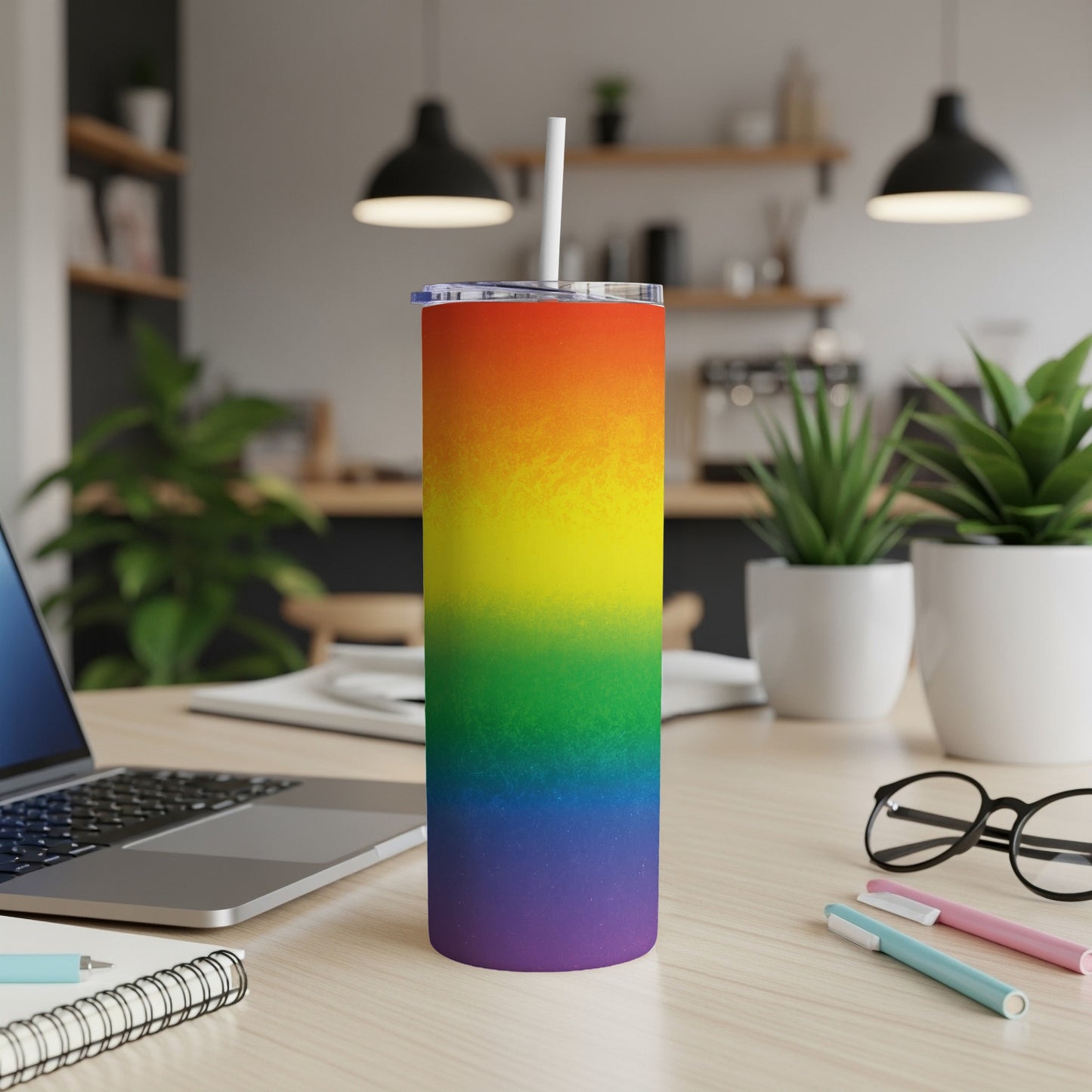 Rainbow gradient tumbler with white straw on a desk.