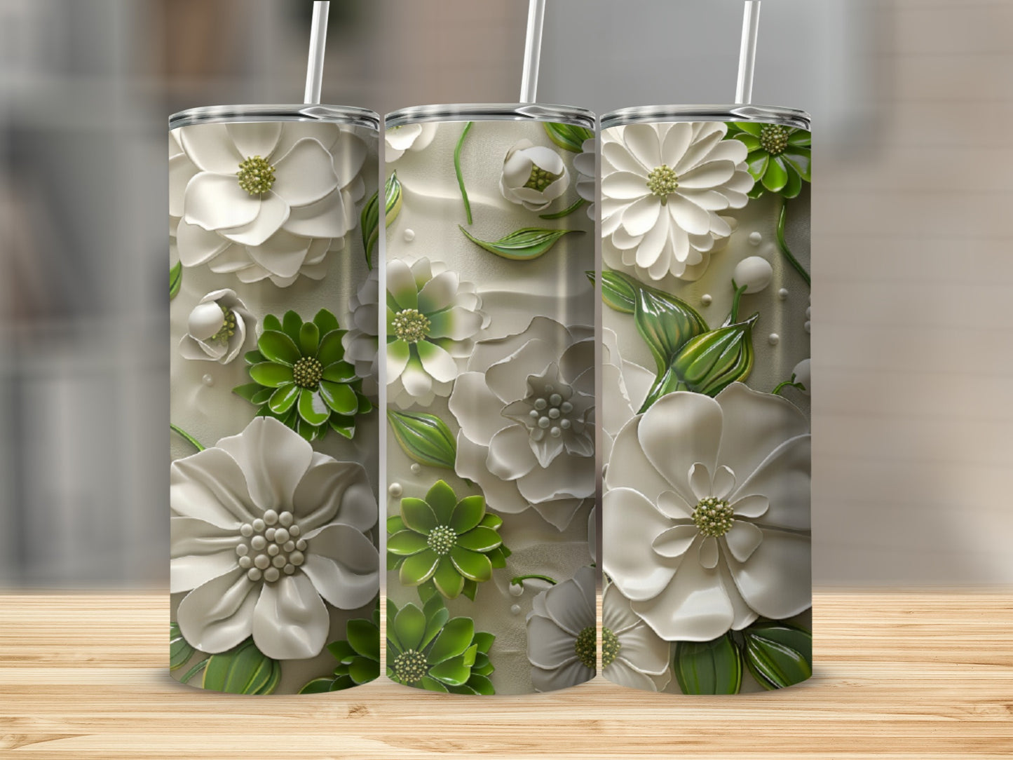 Three white and green floral embossed tumblers on a wooden surface.