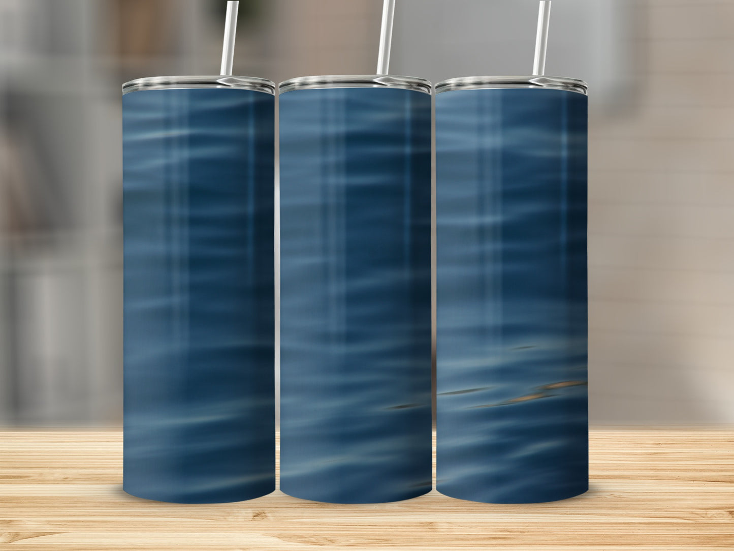 Three tumblers with a blue water ripple pattern stand on a wooden surface.