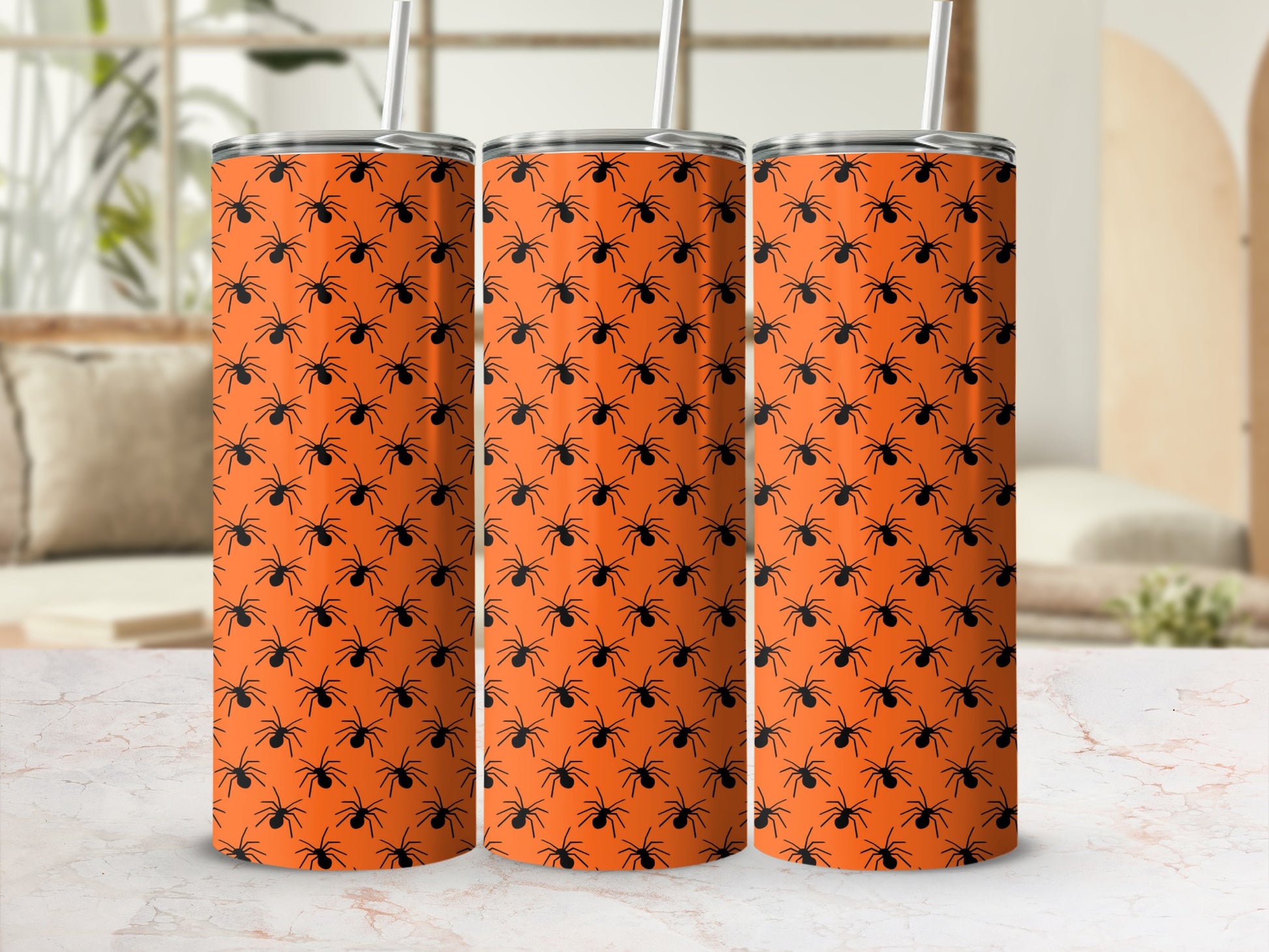 Orange tumblers with a repeating pattern of black spiders and straws.