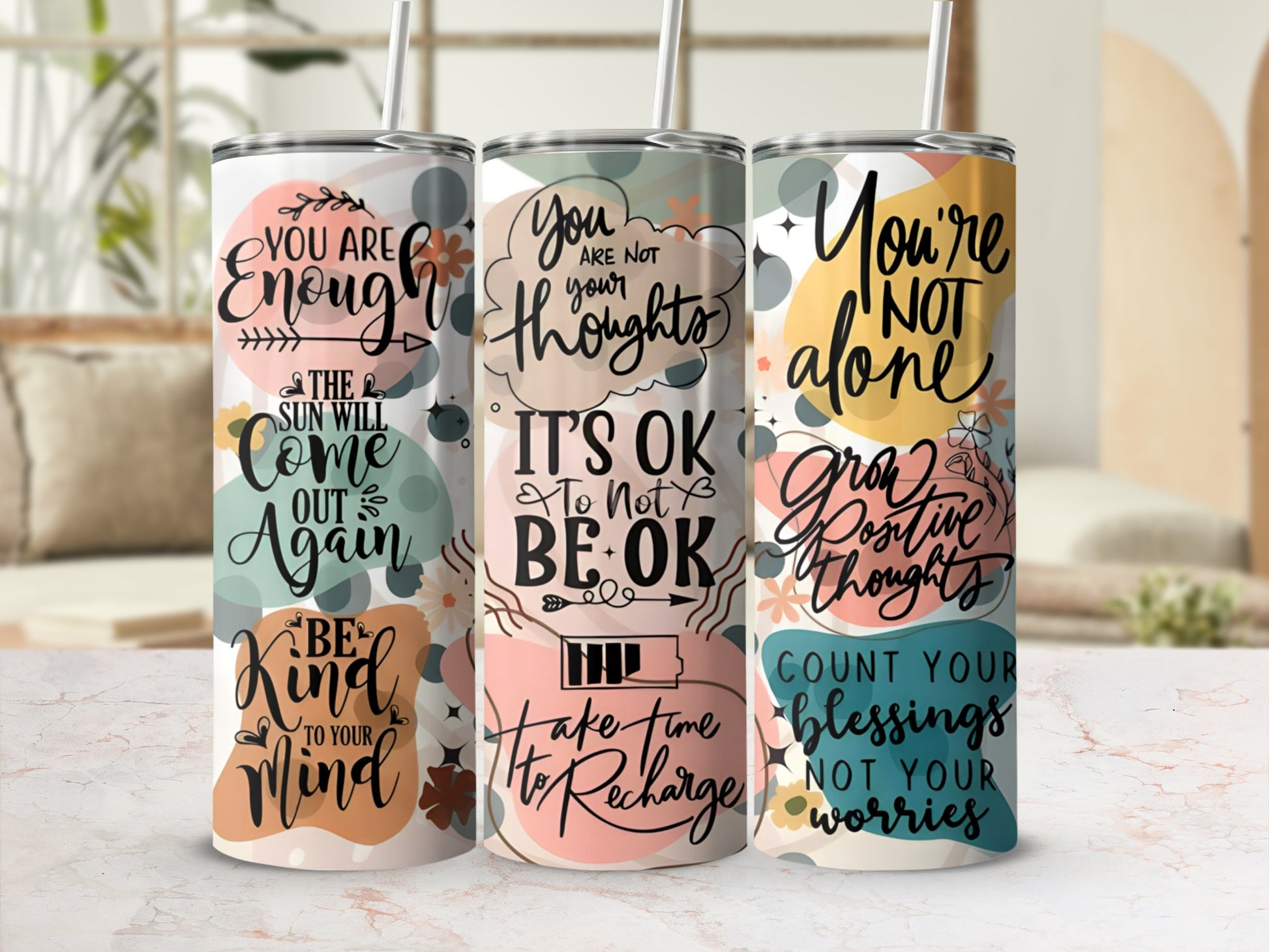 Three tumblers with inspirational quotes and floral designs.