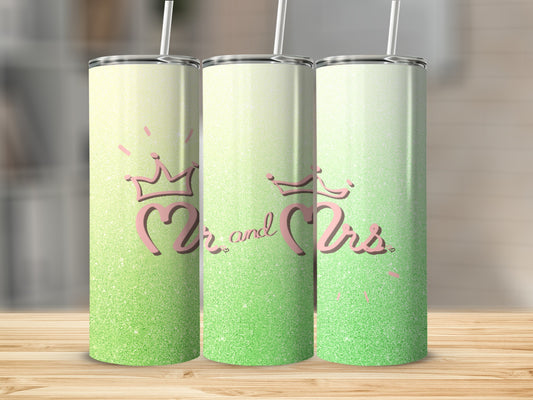 Two glittery tumblers with "Mr and Mrs" crowns and text on a wooden surface.