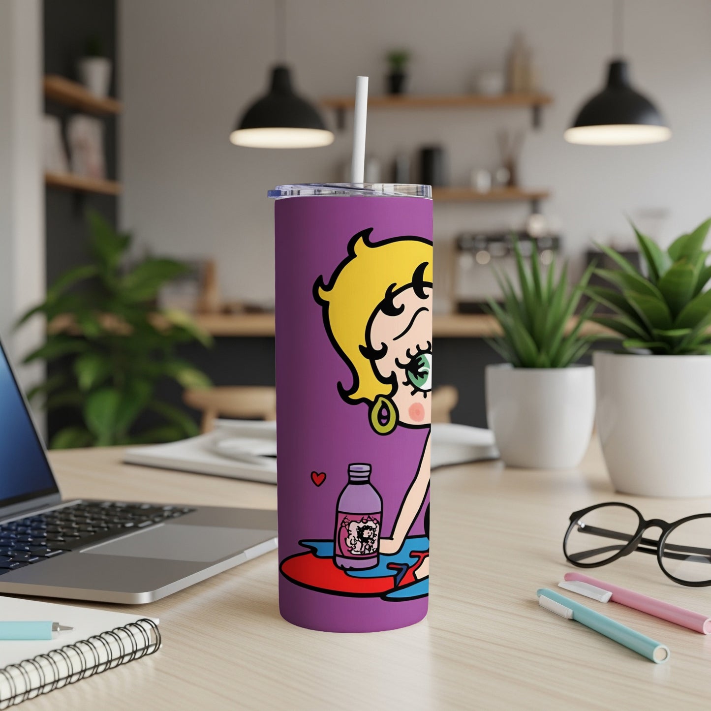 Purple Betty Boop tumbler with a white straw on a desk.