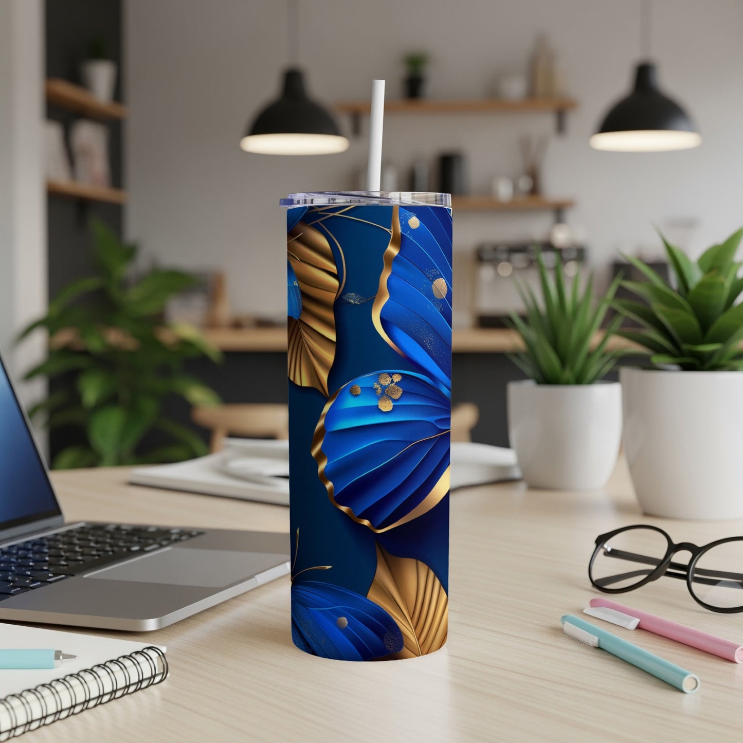 Dark blue tumbler with gold and blue butterfly pattern.
