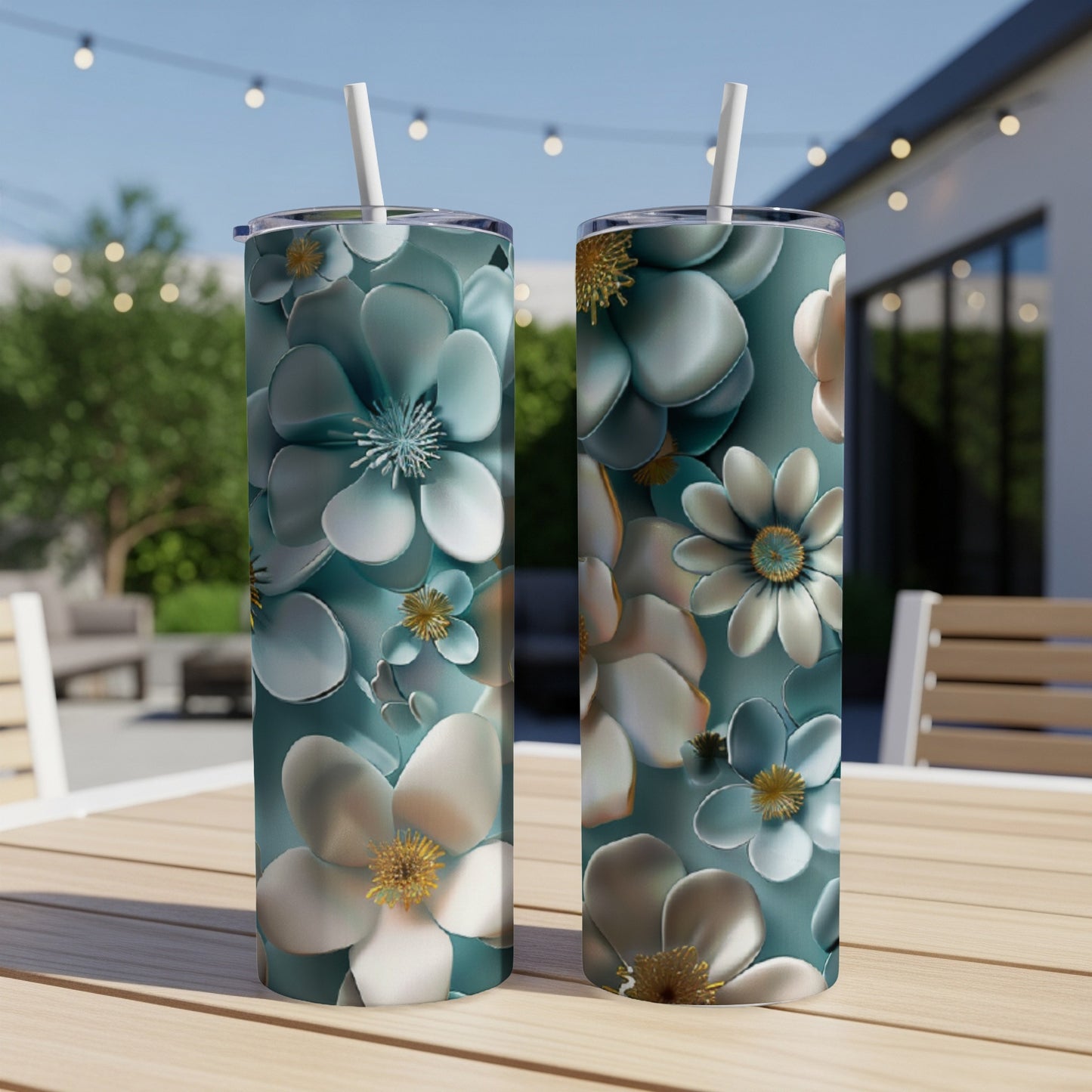 Two tumblers with a teal floral pattern sit on a wooden table outdoors.