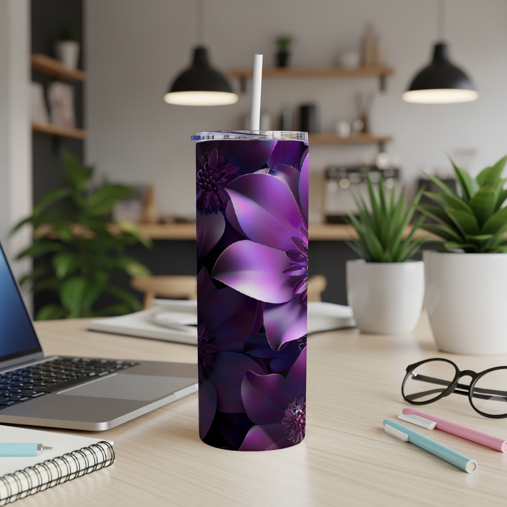 Purple floral patterned tumbler with straw on a desk.