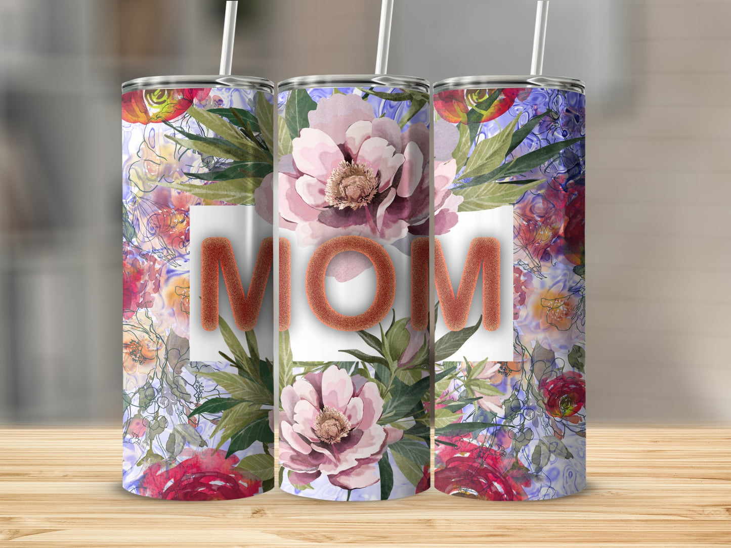 Floral tumbler with "MOM" text and straws, set on a wooden surface.