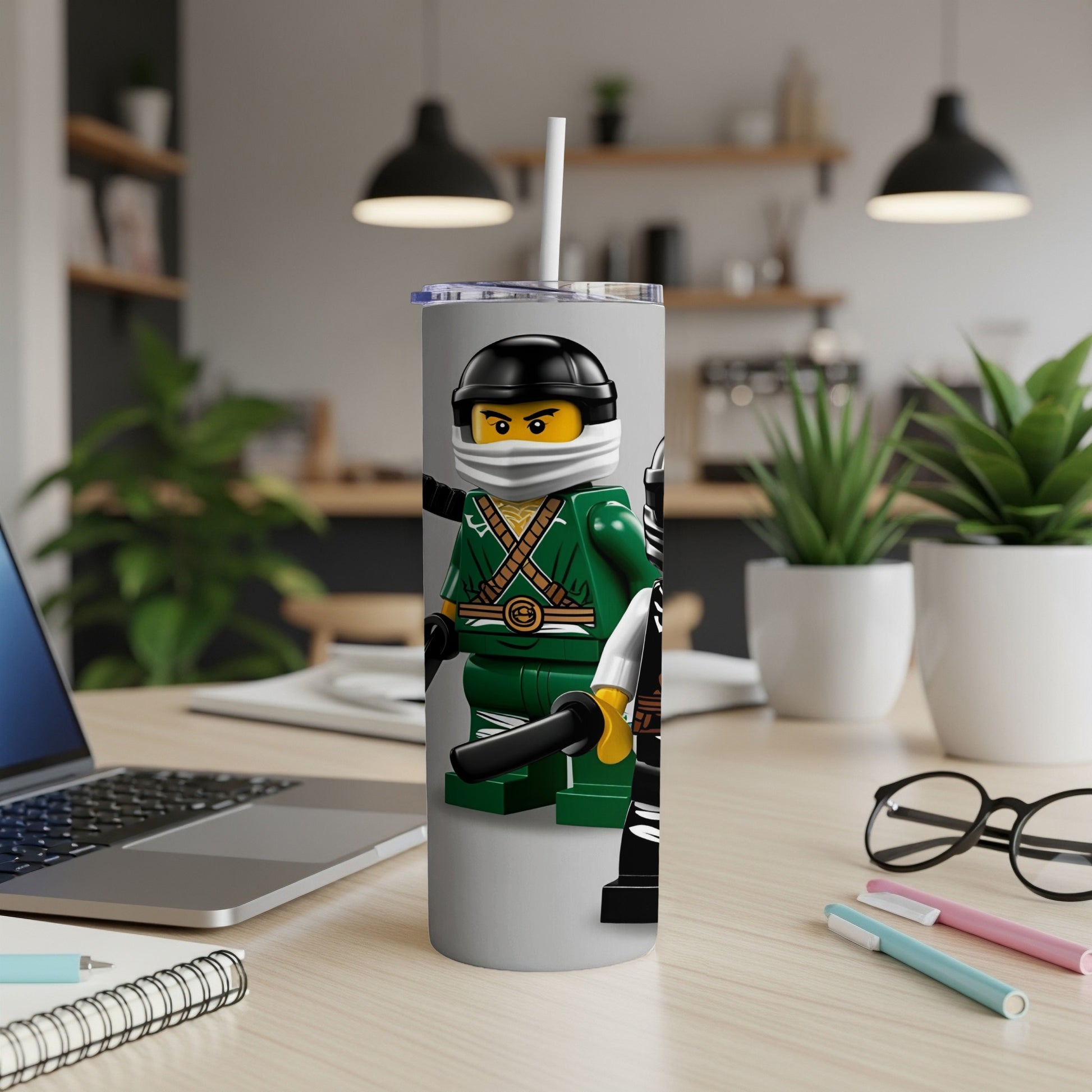 Ninja-themed tumbler with black lid and white straw on a desk.