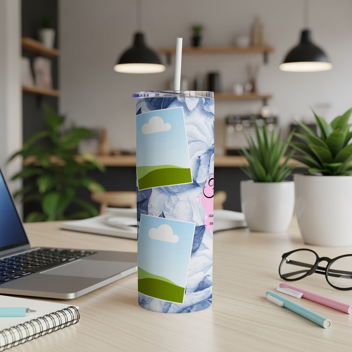 Tumbler with blue floral pattern and framed landscape photos, straw inserted.