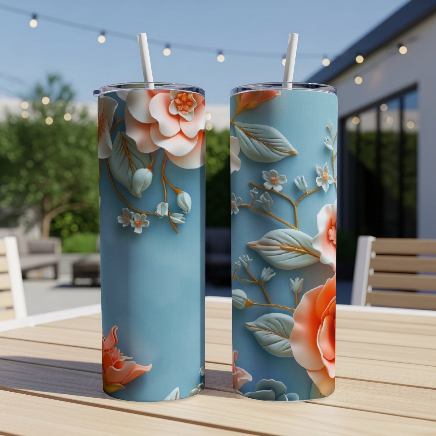 Two blue tumblers with coral and white floral design, on a wooden table.