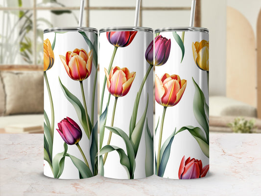 Three tumblers with a floral pattern of tulips on a marble surface.