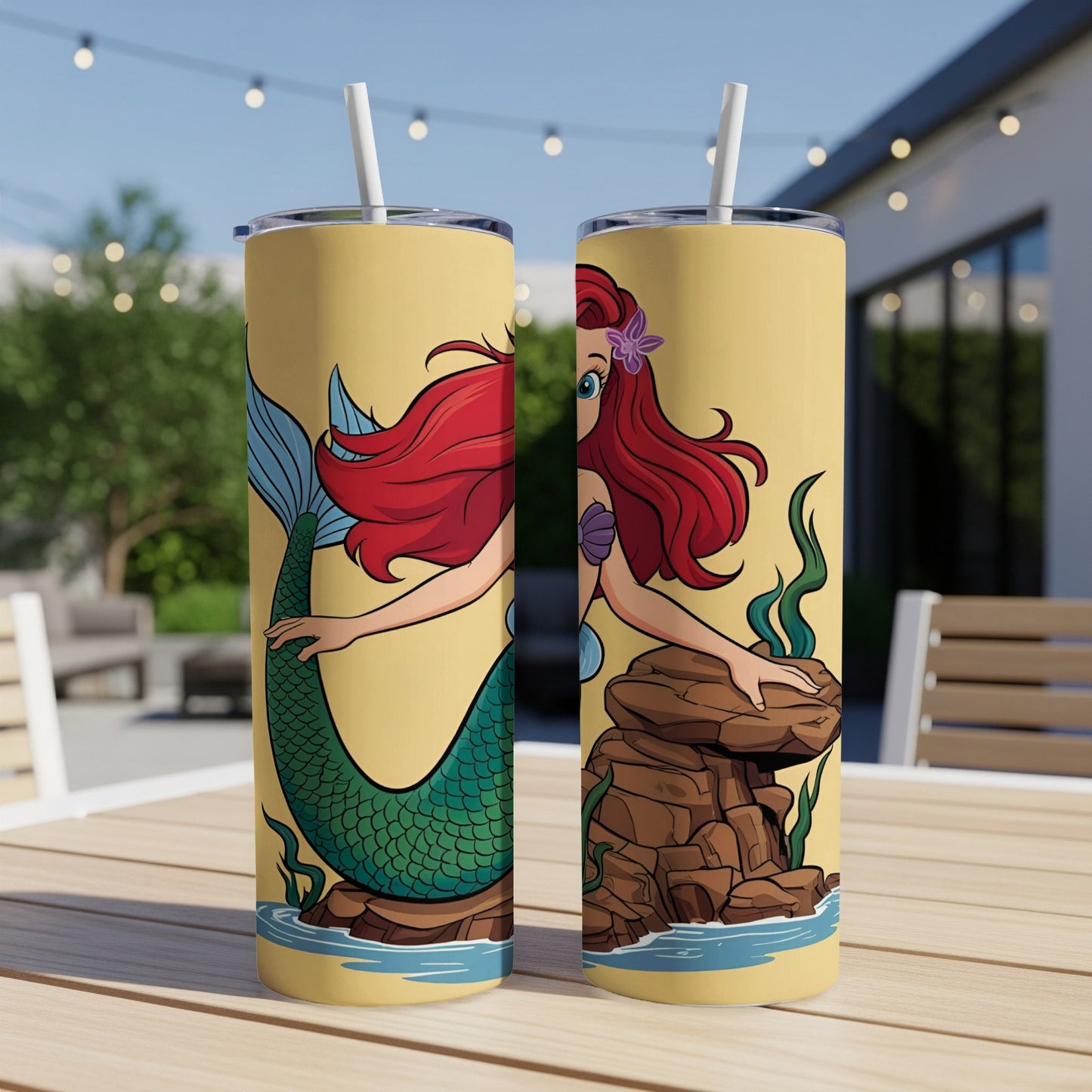 Two yellow tumblers with a cartoon mermaid and rocky underwater scene.
