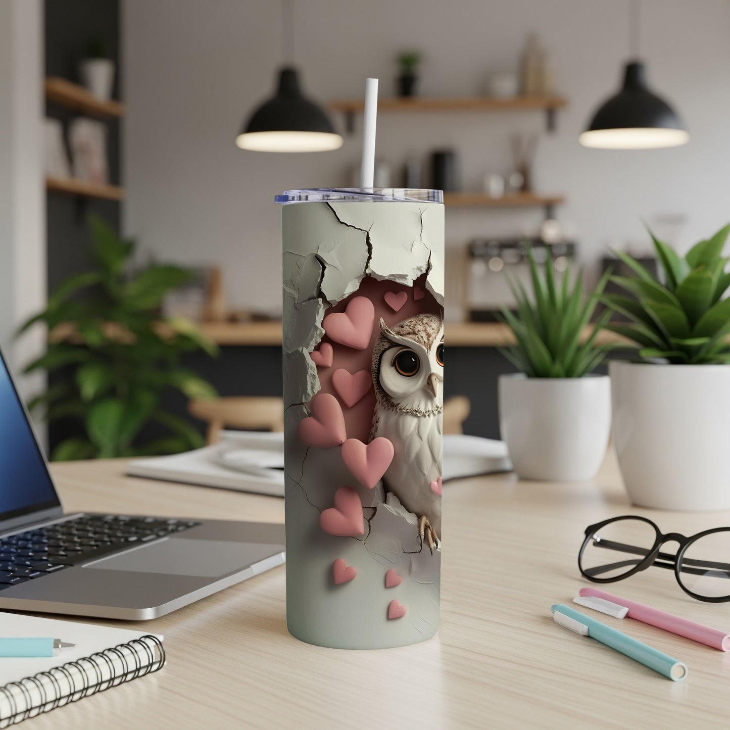 Owl and pink hearts on a white tumbler with a straw, on a desk.