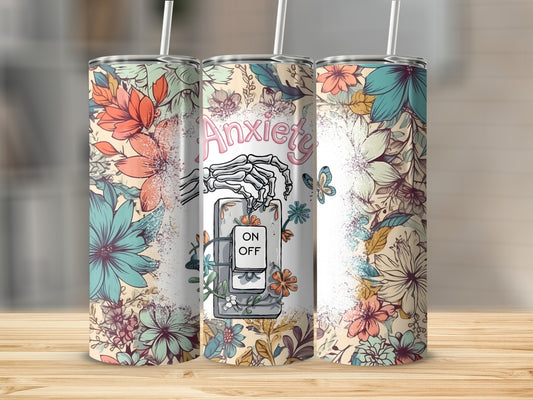 Tumbler with floral design and skeleton hand operating an "Anxiety ON/OFF" switch.