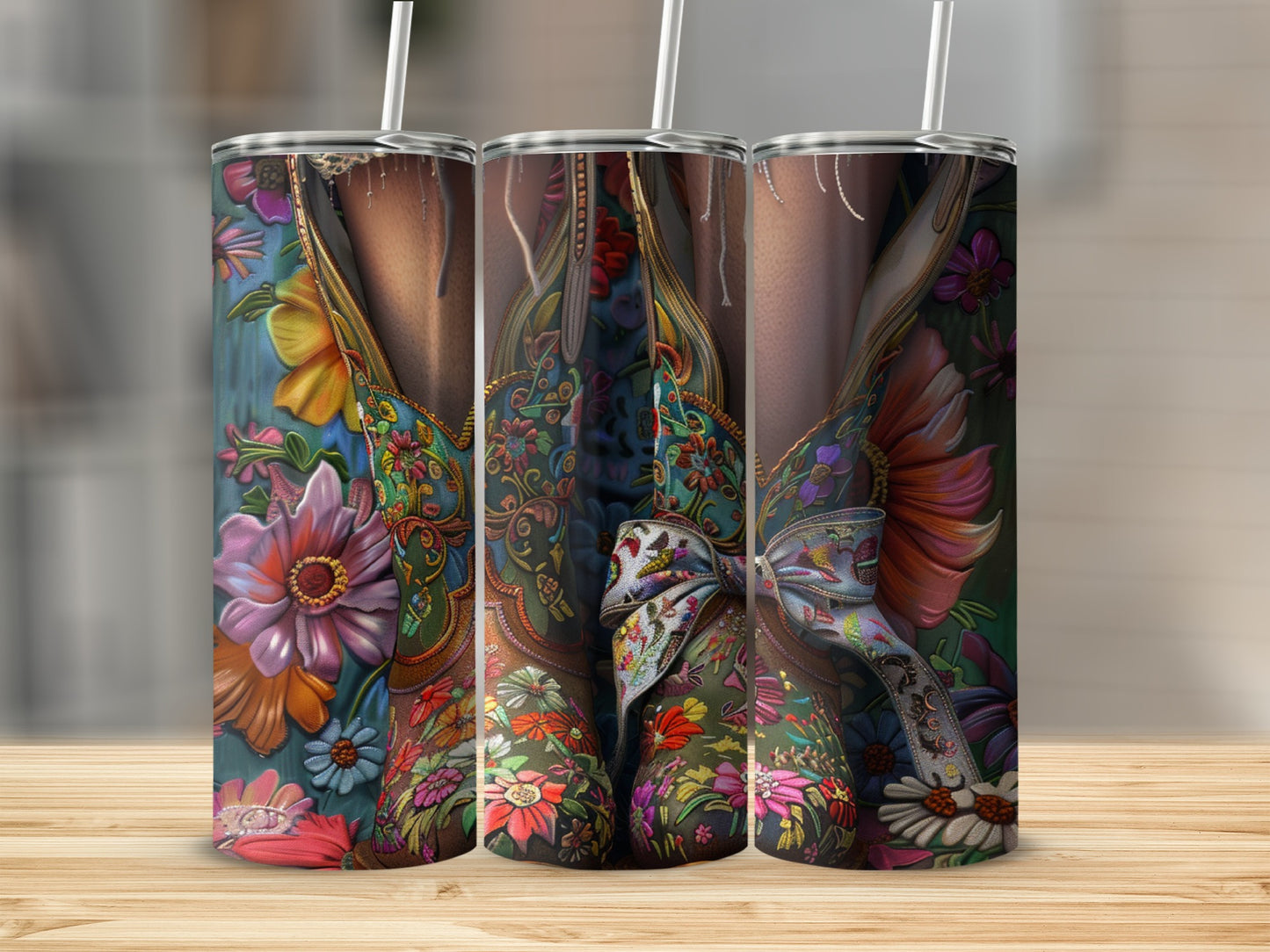Three tumblers with colorful floral western boot designs, tied with ribbons.