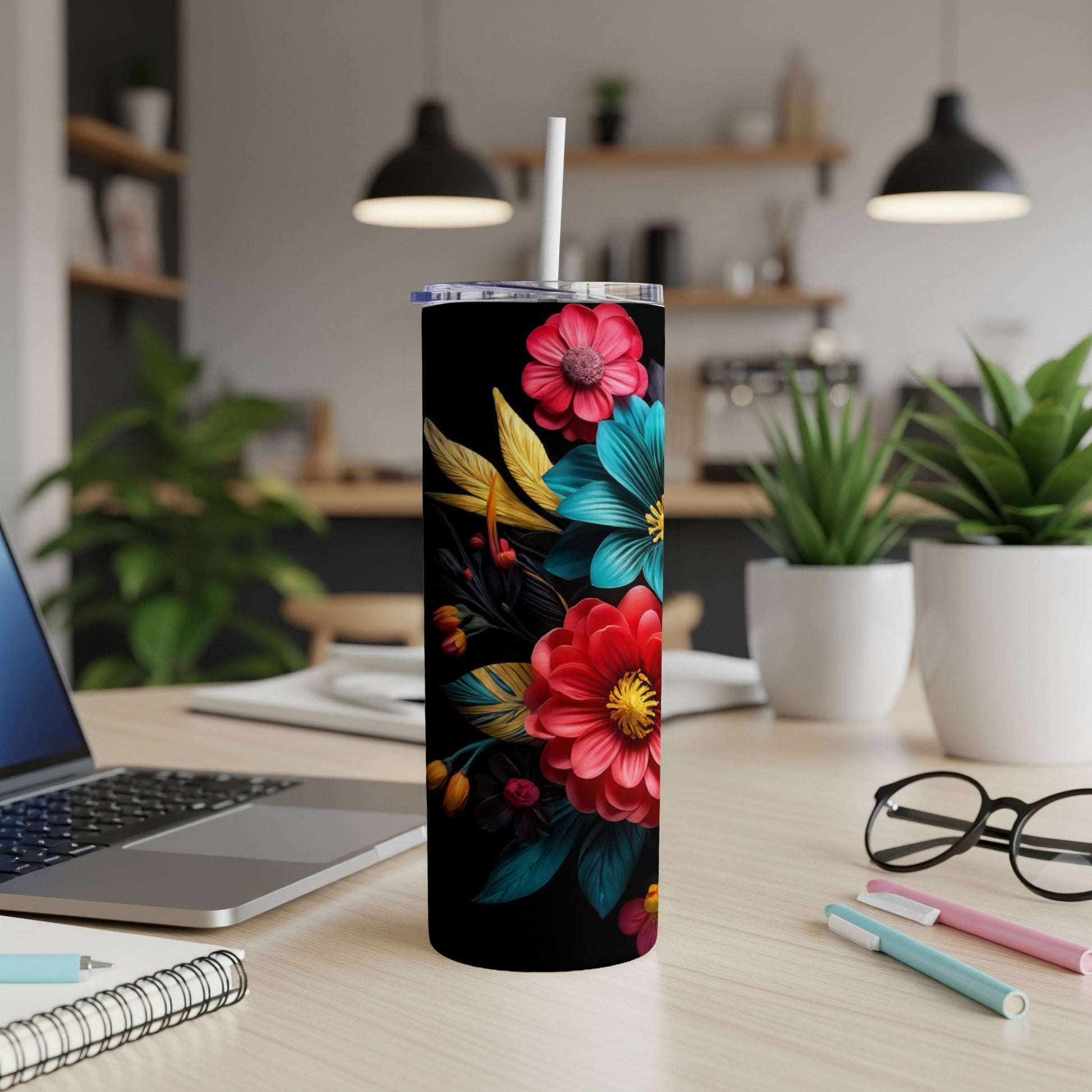 Black tumbler with vibrant floral pattern on a desk.