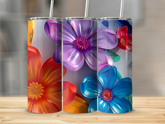 Three tumblers with colorful floral designs stand on a wooden surface.