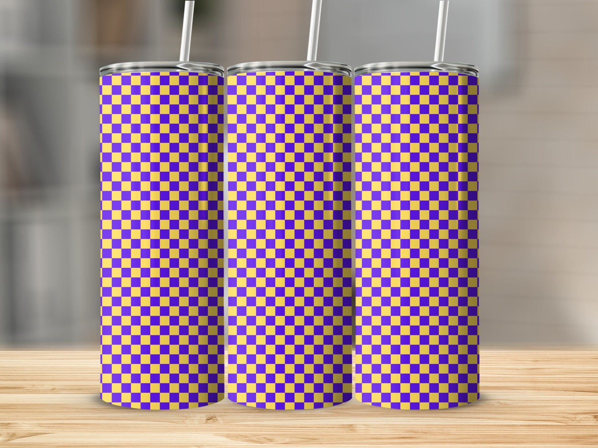 Three tall tumblers with a purple and yellow checkerboard pattern on a wooden surface.