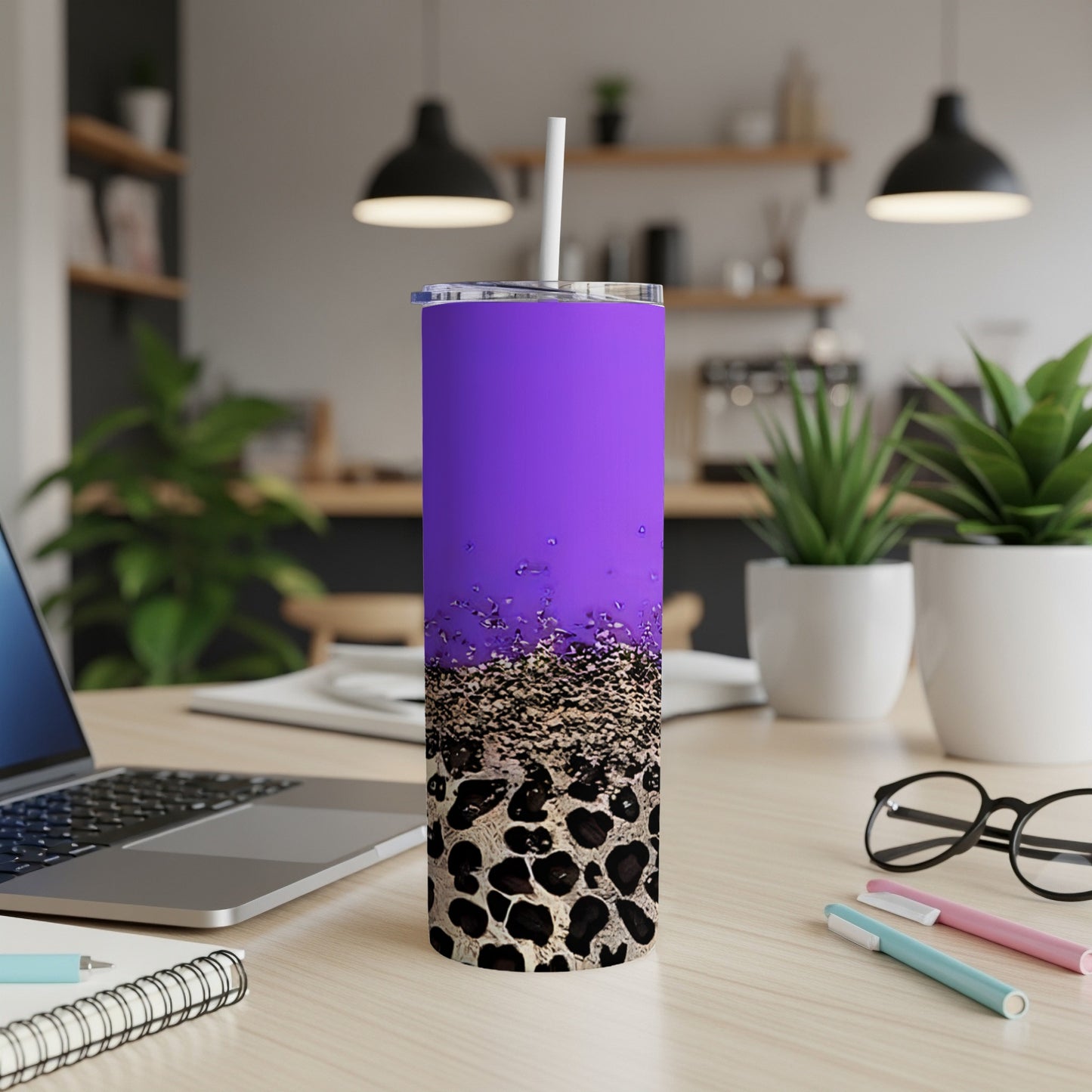 Purple tumbler with leopard print and gold glitter accents on a desk.