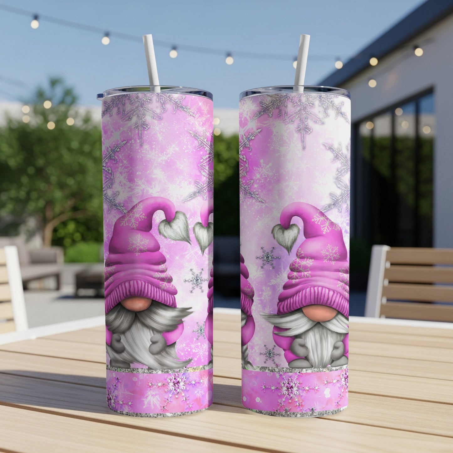Pink gnome tumbler with snowflakes and hearts, on a table.