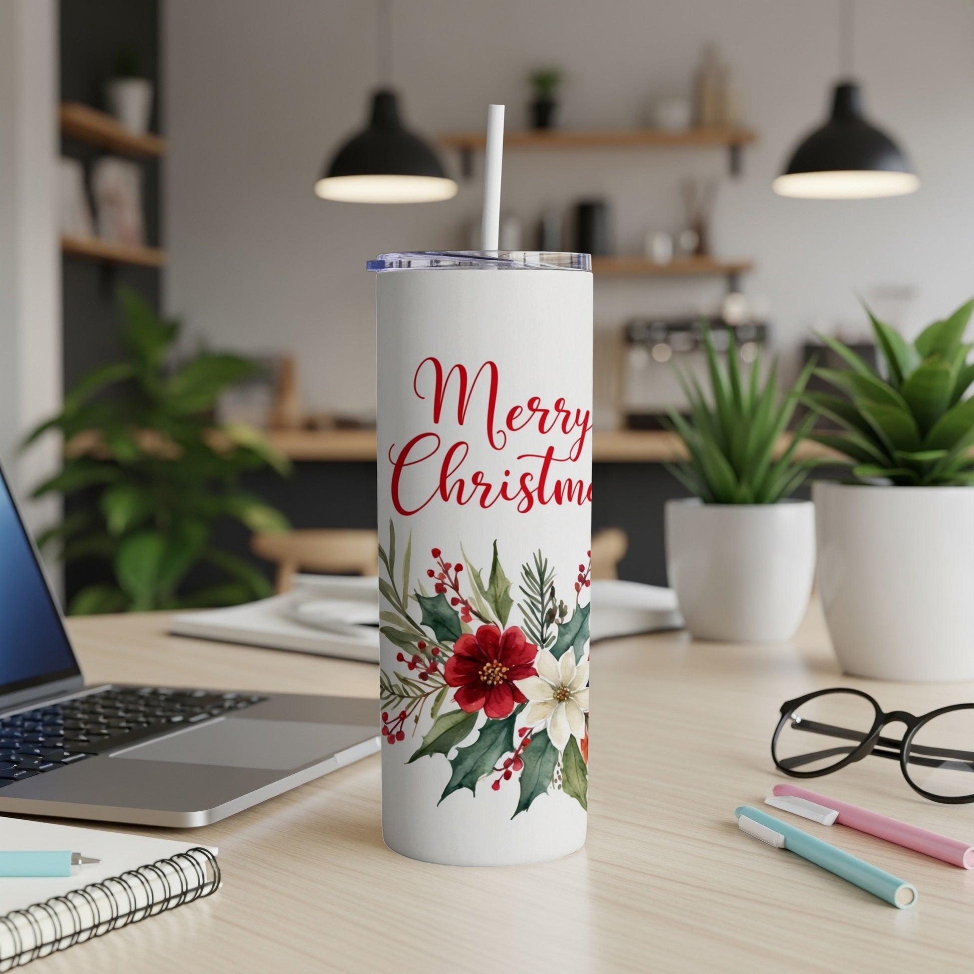 White tumbler with Merry Christmas floral design and straw on desk.