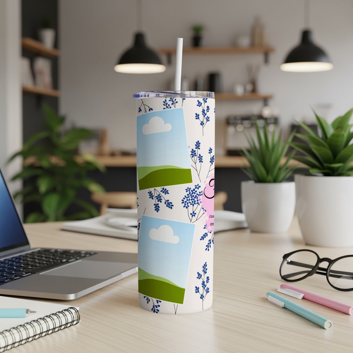 Tumbler with photos, blue flowers, and pink lettering on a desk.