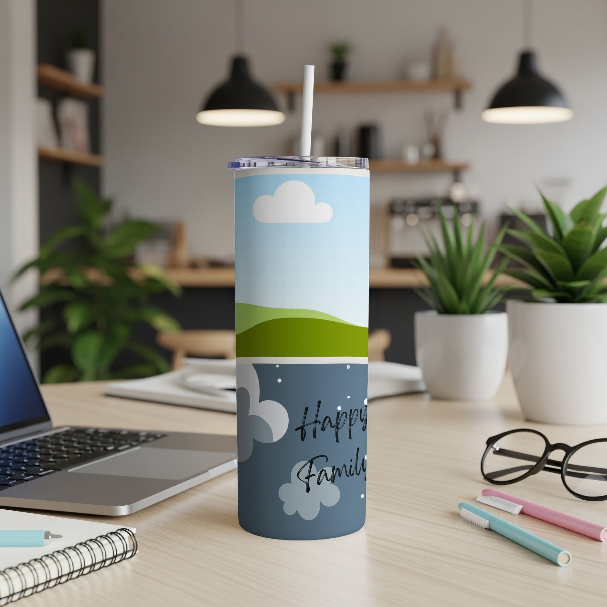 Tumbler with sky, clouds, green hills, and text "Happy Family" on a desk.
